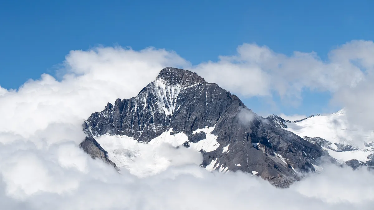 Snowy summit rising above the clouds — Nicolas Marincic