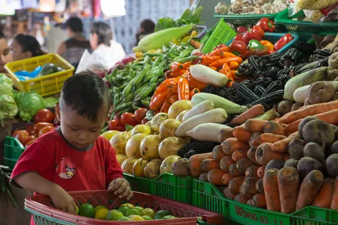 Child among the vegetables at Belén market, Iquitos, Peru — Nicolas Marincic