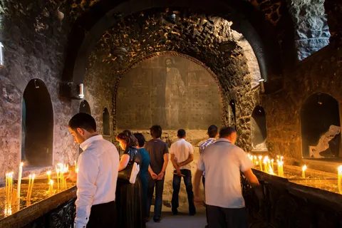 Worshippers and candles in a stone church, Armenia — Nicolas Marincic