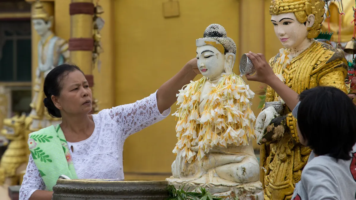 Flower offering to a Buddha statue, Burma — Nicolas Marincic