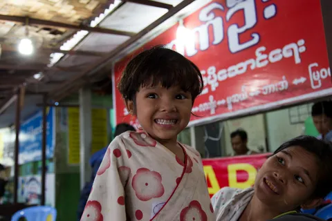 Smiling child beneath a shop sign, Burma — Nicolas Marincic