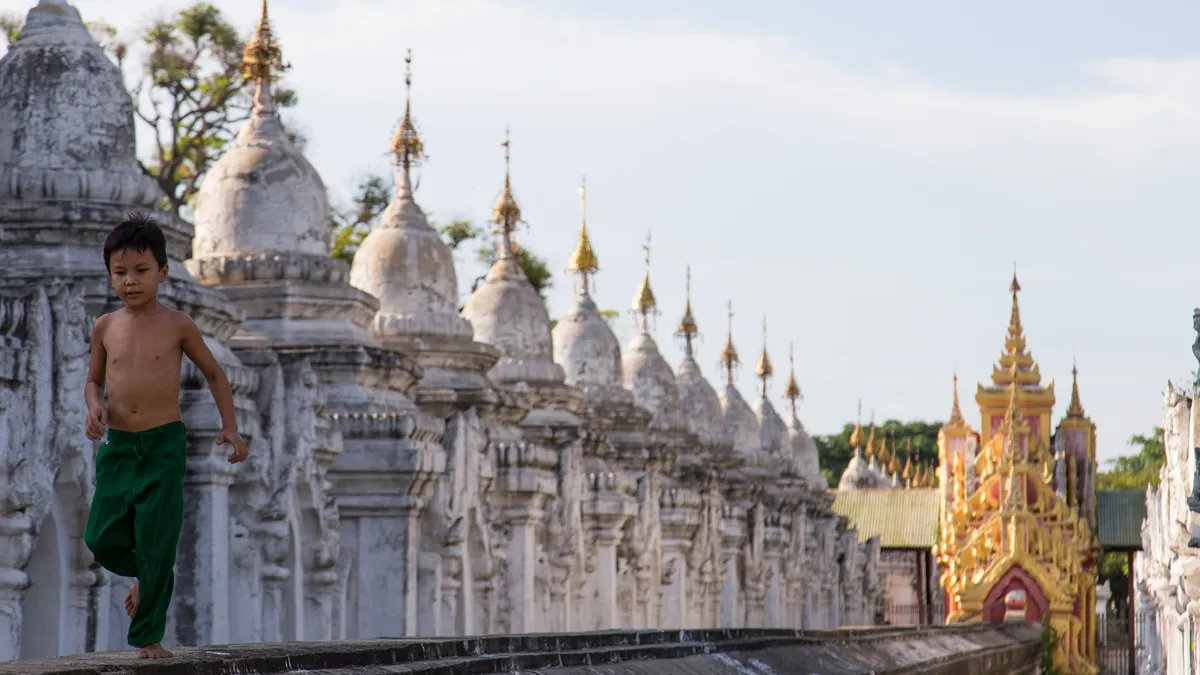 Boy before the white stupas of Kuthodaw Pagoda, Burma — Nicolas Marincic