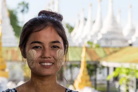 Young woman with thanaka before white stupas, Burma — Nicolas Marincic