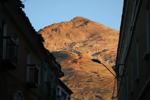 Cerro Rico glowing at sunset from a Potosí street, Bolivia — Nicolas Marincic