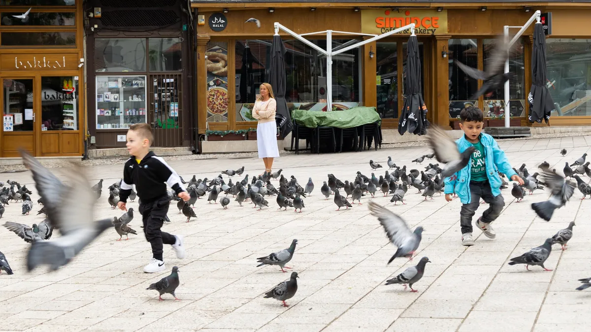 Children running among the pigeons, Bosnia and Herzegovina — Nicolas Marincic