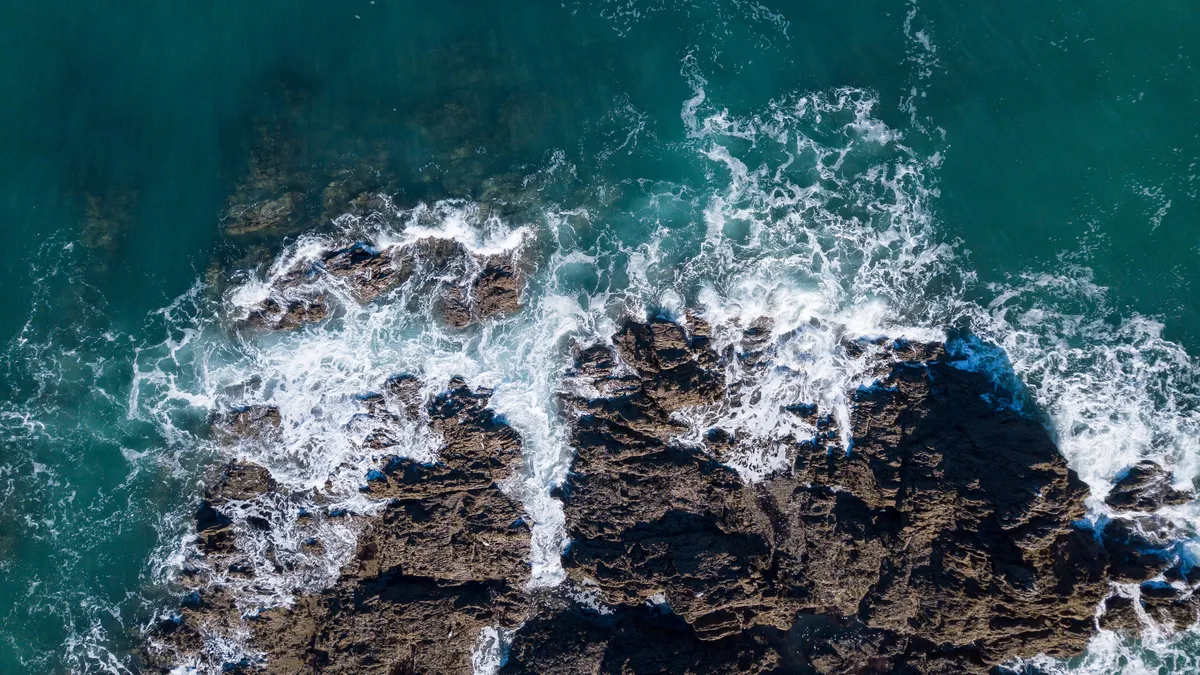 Vagues sur les récifs sombres, vues d’en haut, France — Nicolas Marincic