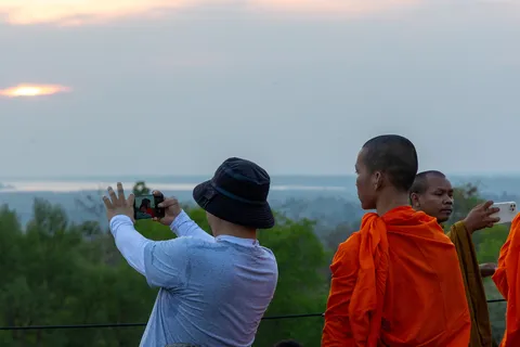 Monks and a visitor photographing dusk, Cambodia — Nicolas Marincic