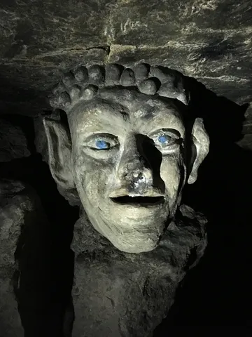 Carved head with blue eyes in the catacombs, France — Nicolas Marincic