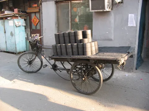 Coal briquettes on a tricycle in a hutong, China — Nicolas Marincic