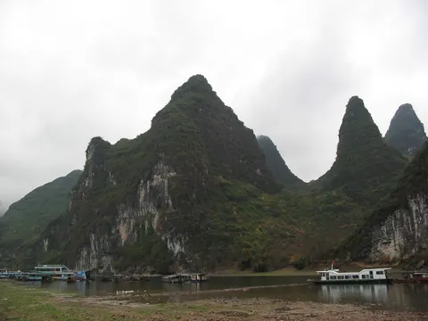 Karst peaks above boats on the Li River, China — Nicolas Marincic