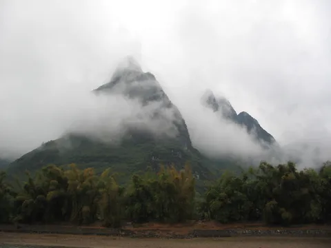 Karst peak wrapped in cloud, Li River, China — Nicolas Marincic