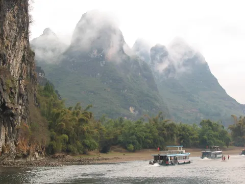 Cruise boats beneath misty karst, Li River, China — Nicolas Marincic