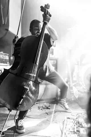 Bruit ≤ cellist on a white stage, black and white, France — Nicolas Marincic