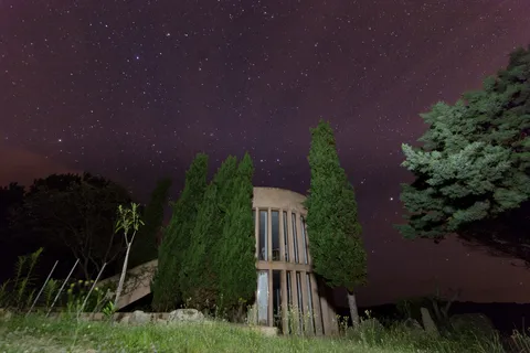 Starry sky over cypresses and an old gate, Corsica, France — Nicolas Marincic