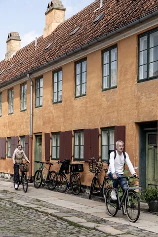 Cyclistes devant les maisons ocre de Nyboder, Danemark — Nicolas Marincic