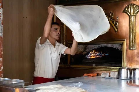 Baker tossing dough, Egypt — Nicolas Marincic