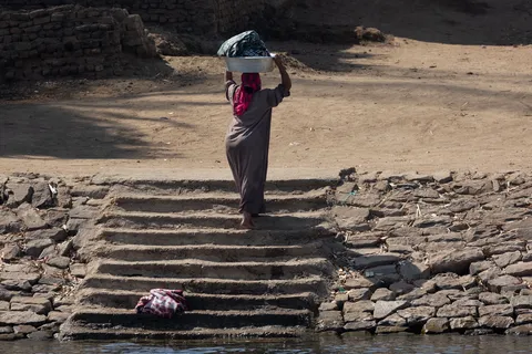 Woman carrying a basin on the Nile bank, Egypt — Nicolas Marincic