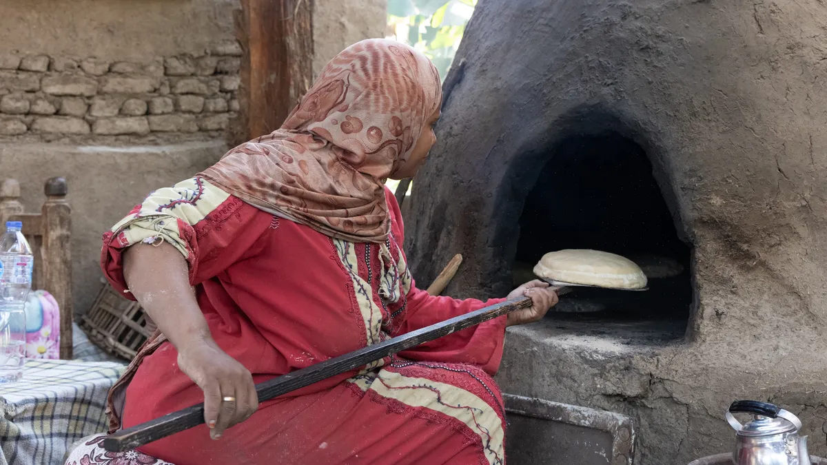 Woman baking bread in a clay oven, Egypt — Nicolas Marincic