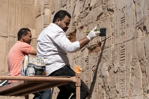 Restorers cleaning a wall of hieroglyphs, Egypt — Nicolas Marincic