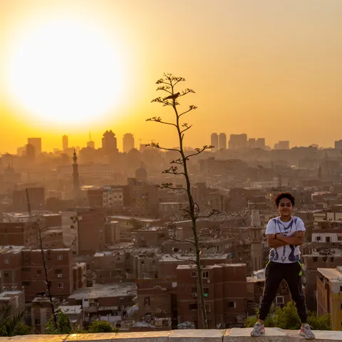 Child before the sun setting over the city, Egypt — Nicolas Marincic