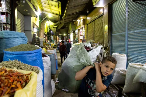 Boy carrying a sack through the spice souk, Egypt — Nicolas Marincic