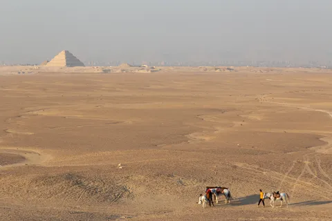 Riders in the desert facing the pyramids, Egypt — Nicolas Marincic