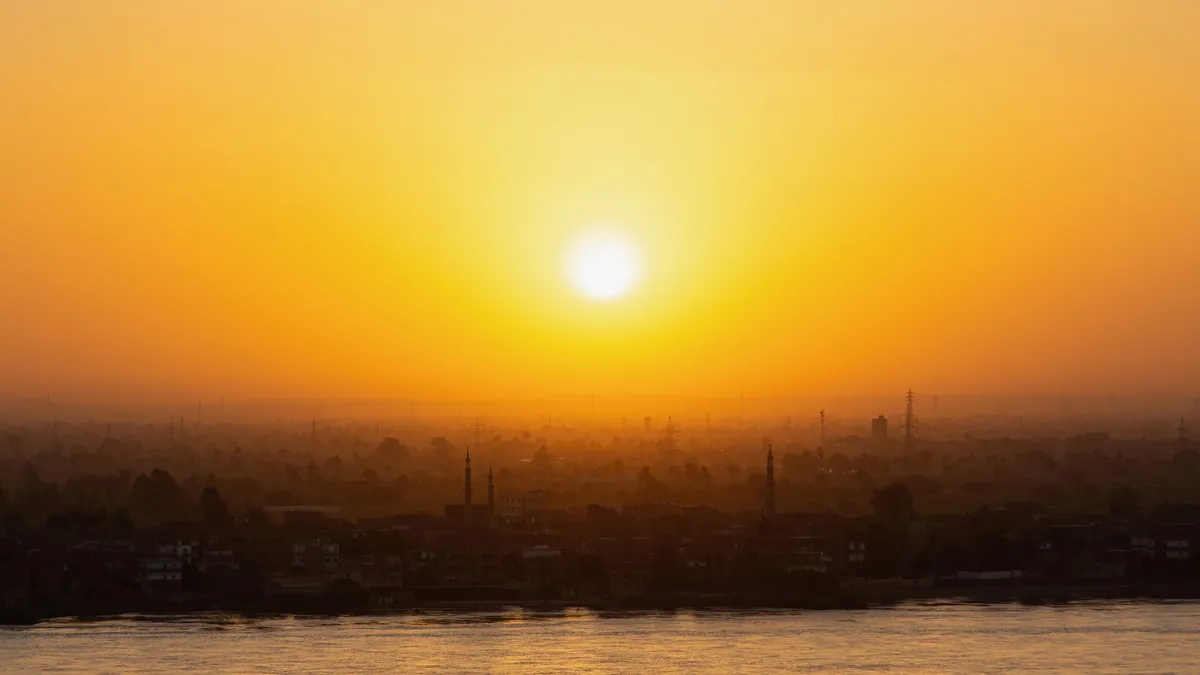 Sun setting over the city in the haze, Egypt — Nicolas Marincic