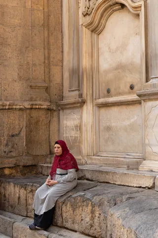 Woman in a red headscarf on mosque steps, Egypt — Nicolas Marincic