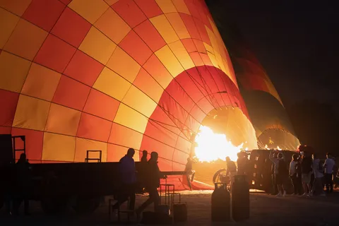 Hot-air balloon inflating by burner flame at dawn, Luxor, Egypt — Nicolas Marincic