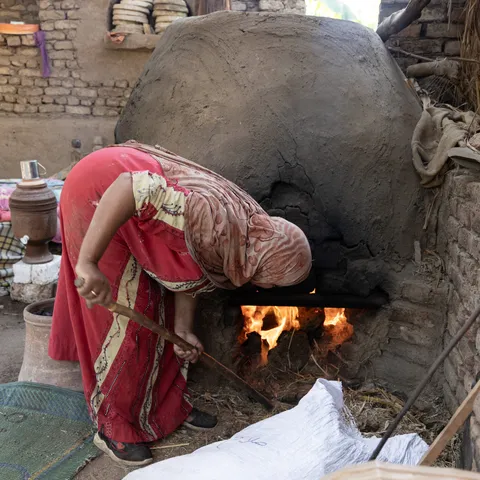 Nubian woman baking bread in a clay oven, Egypt — Nicolas Marincic
