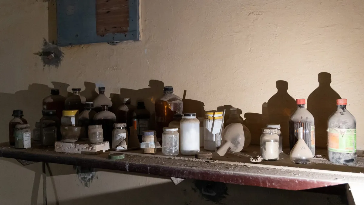Dusty bottles on an abandoned laboratory shelf, Egypt — Nicolas Marincic
