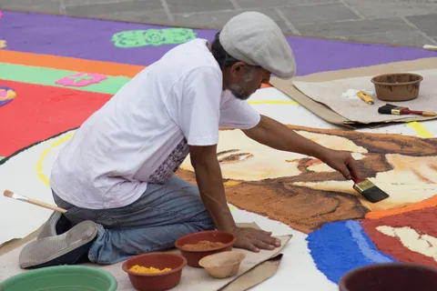 Artist finishing a sawdust carpet on Good Friday, El Salvador — Nicolas Marincic
