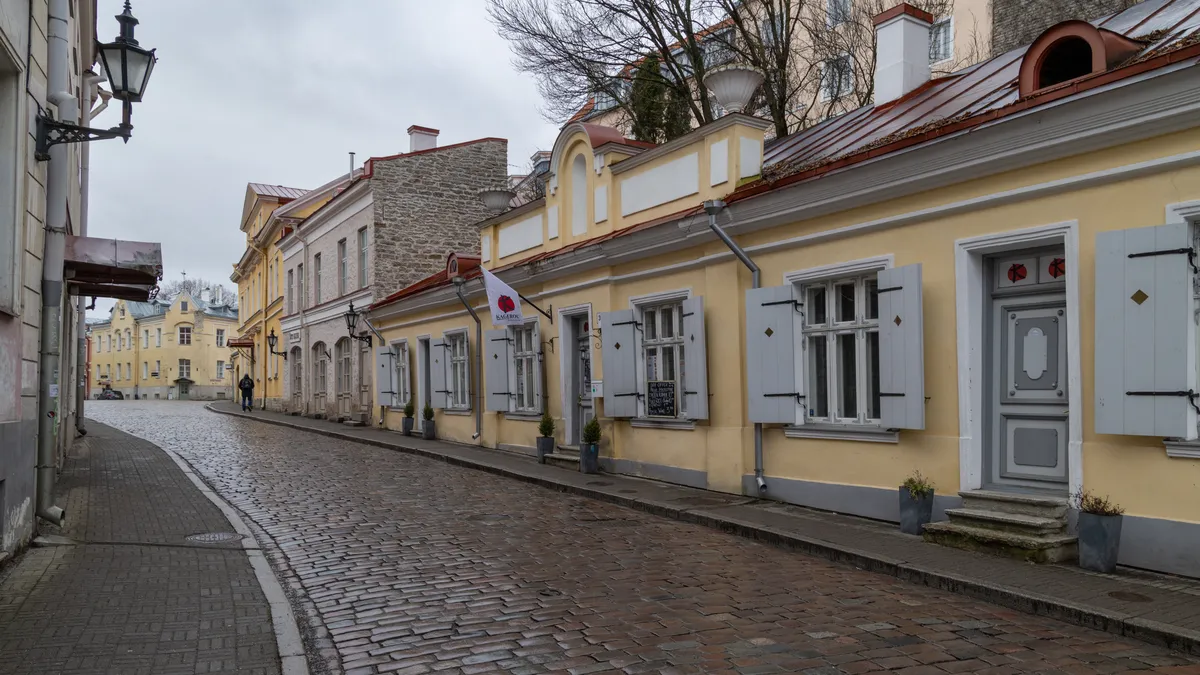 Rue pavée en courbe et maisons jaunes, Tallinn, Estonie — Nicolas Marincic