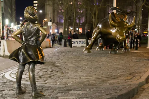 Fearless Girl facing the Charging Bull, Wall Street at night, United States — Nicolas Marincic