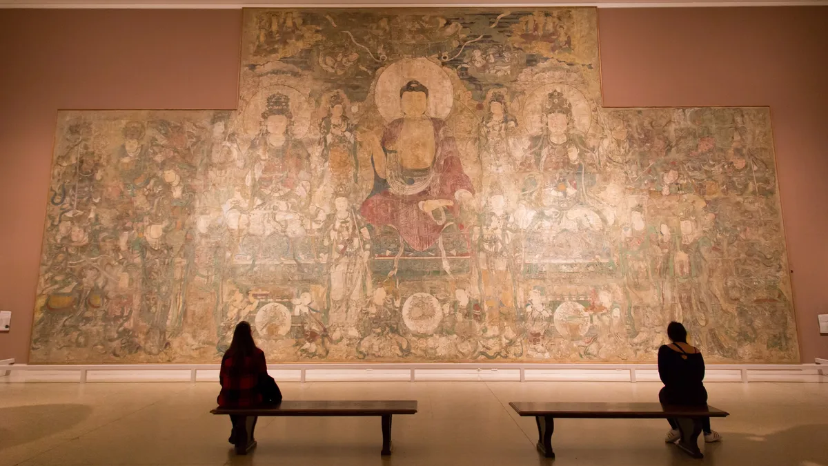 Visitors before a large Buddhist mural, Metropolitan Museum, United States — Nicolas Marincic