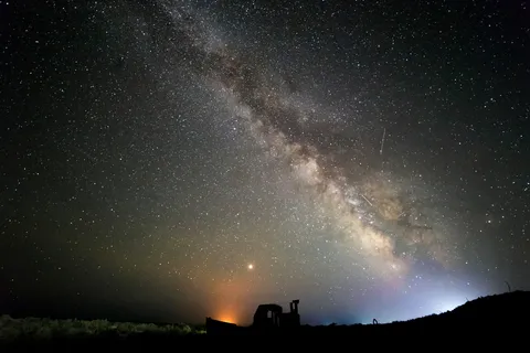 Milky Way arching over a field and a tractor, Uzbekistan — Nicolas Marincic