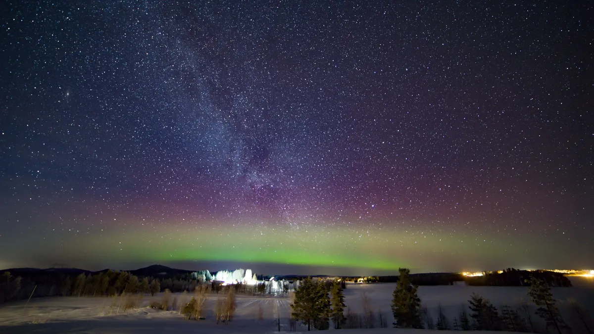 Aurora borealis beneath the Milky Way over a snowy lake, Sweden — Nicolas Marincic