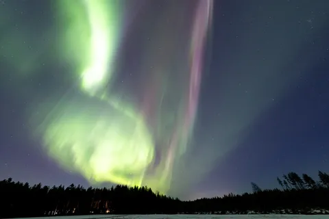 Volute d’aurore au-dessus d’un lac et de la forêt, Finlande — Nicolas Marincic