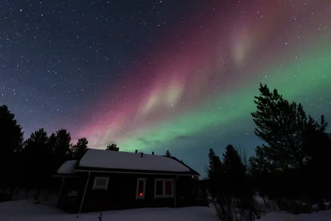 Aurore boréale au-dessus d’un chalet, Finlande — Nicolas Marincic
