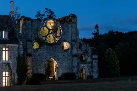 Façade et rosace éclairée à l’heure bleue, Vaux-de-Cernay, France — Nicolas Marincic
