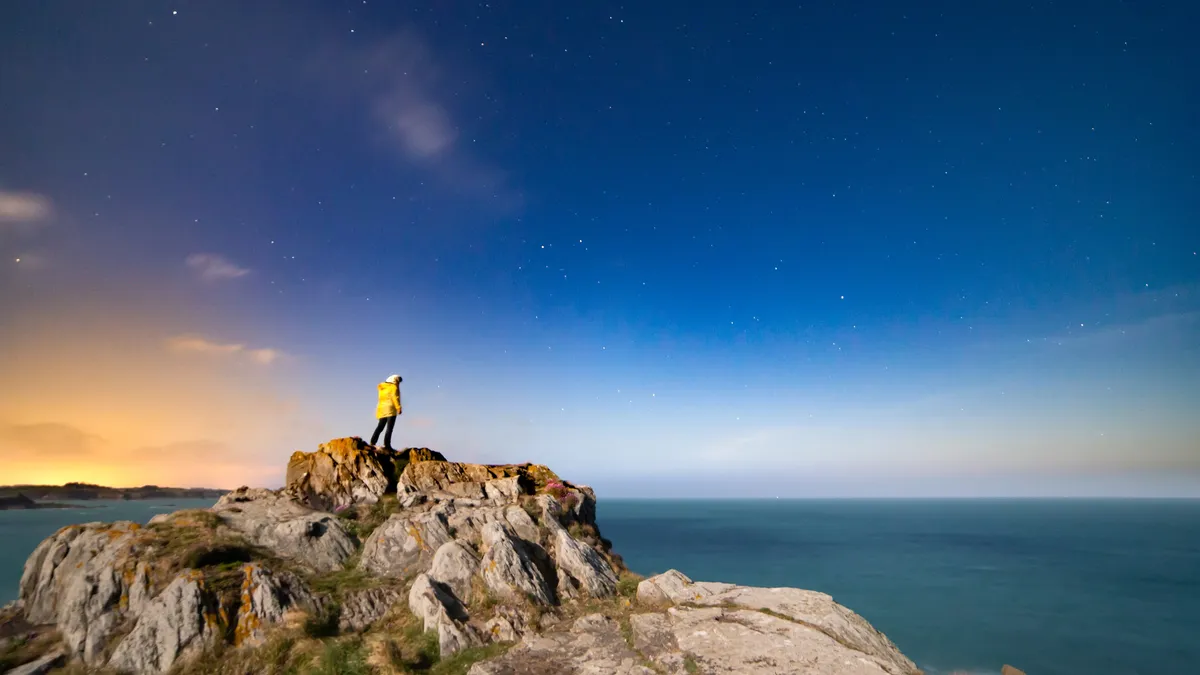 Figure on a rock at blue hour, France — Nicolas Marincic