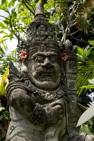 Gardien de pierre et fleur de frangipanier, Ubud, Indonésie — Nicolas Marincic