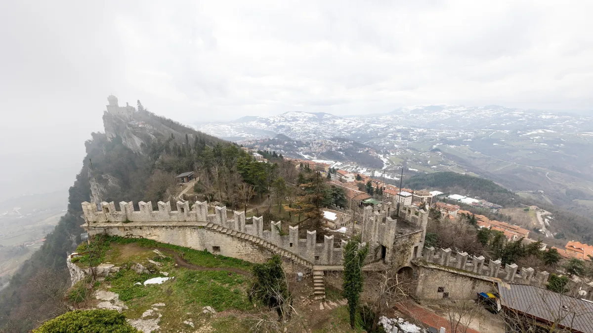 Crenellated walls on the ridge in fog, San Marino — Nicolas Marincic