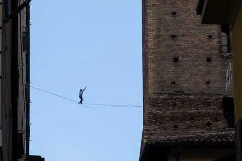 Funambule entre les tours médiévales de Bologne, Italie — Nicolas Marincic
