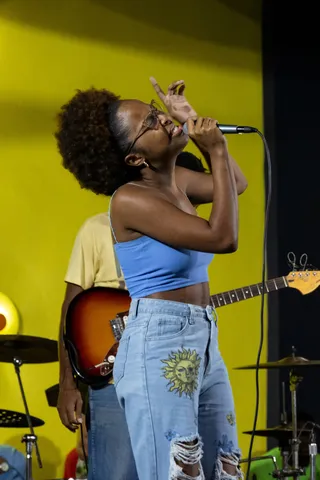 Young singer performing live against a yellow backdrop, Jamaica — Nicolas Marincic