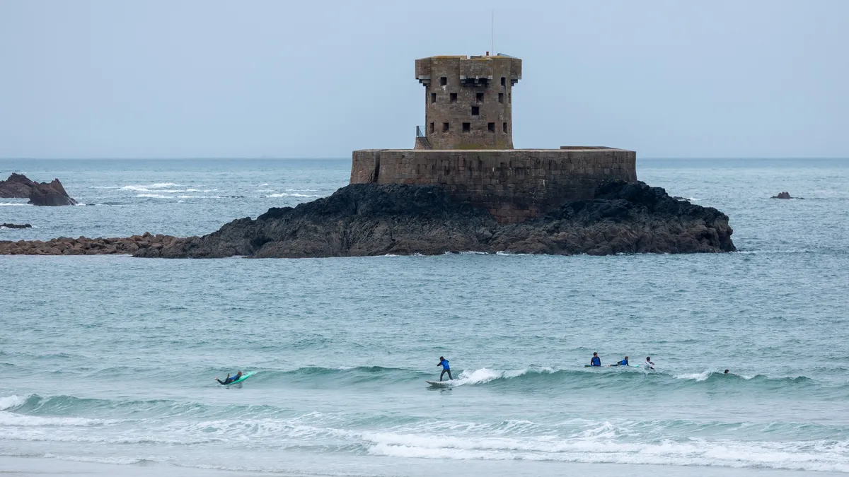 Tour de La Rocco et surfeurs, baie de St Ouen, Jersey, Royaume-Uni — Nicolas Marincic