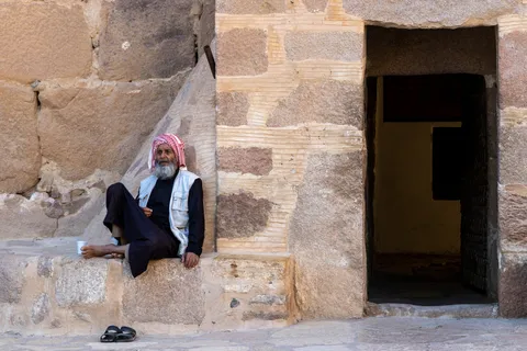 Man in a keffiyeh seated on a granite doorstep, Egypt — Nicolas Marincic