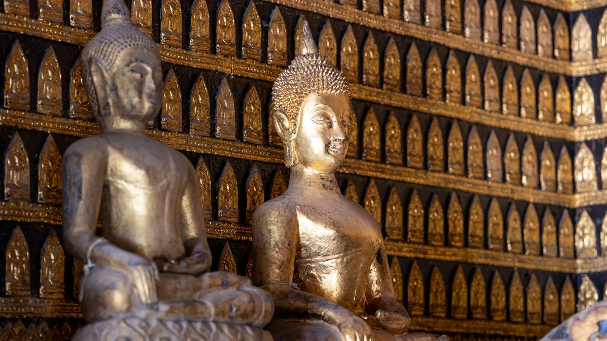 Buddhas before a wall of votive tablets, Luang Prabang, Laos — Nicolas Marincic