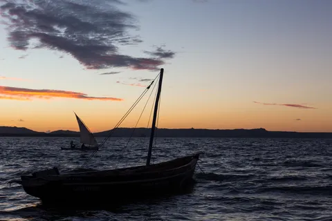 Outrigger canoe silhouetted at sunset, Diego Bay, Madagascar — Nicolas Marincic