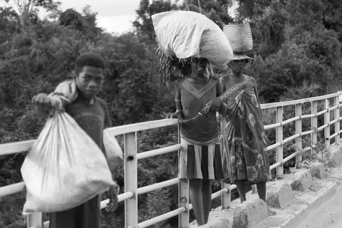 People carrying sacks across a bridge, Madagascar — Nicolas Marincic